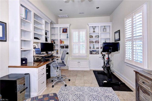 office space featuring a wealth of natural light, visible vents, and light tile patterned floors