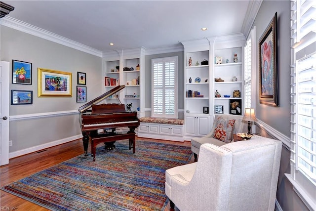 sitting room with built in features, dark wood-type flooring, baseboards, and ornamental molding