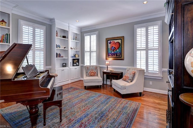 living area with light wood finished floors, a healthy amount of sunlight, baseboards, and ornamental molding