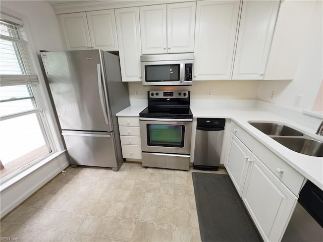 kitchen featuring white cabinetry, stainless steel appliances, light countertops, and a sink