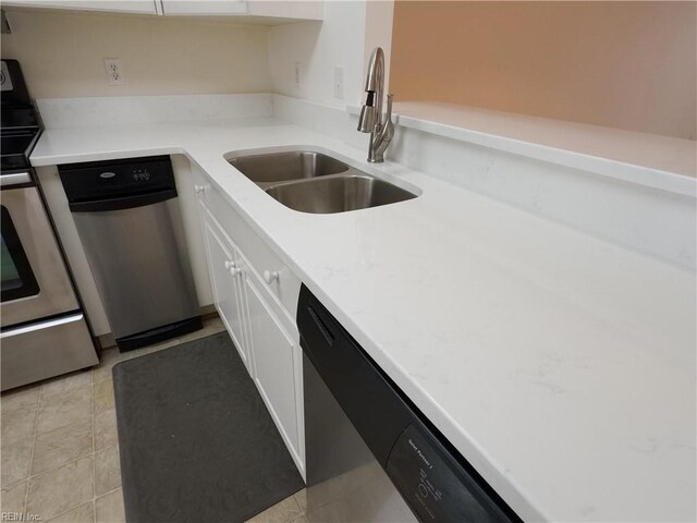 kitchen with light tile patterned floors, white cabinets, appliances with stainless steel finishes, and a sink