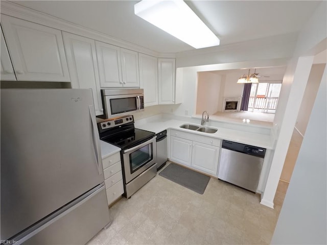 kitchen featuring white cabinetry, stainless steel appliances, light countertops, and a sink