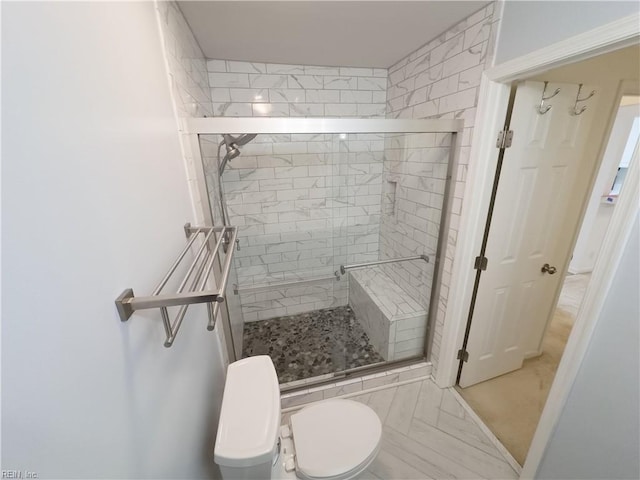 bathroom featuring a shower stall and toilet