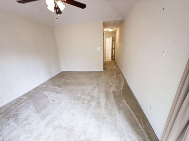 spare room featuring baseboards, light carpet, and ceiling fan