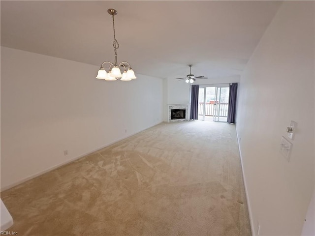 unfurnished living room with light carpet, a fireplace, and ceiling fan with notable chandelier