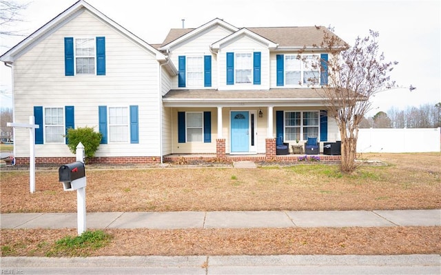 view of front facade with a porch, fence, and a front yard