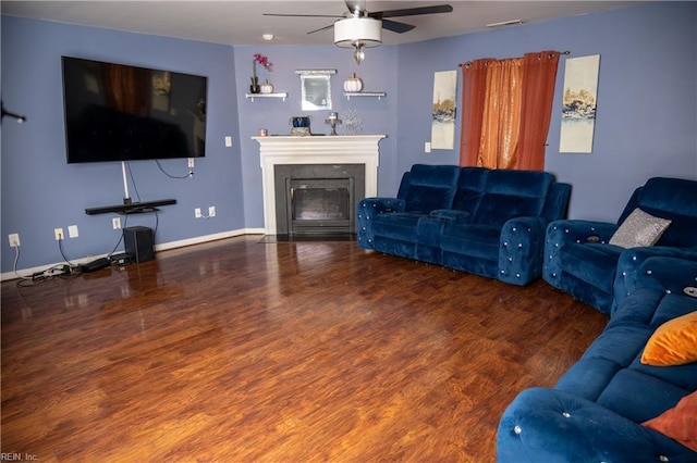 living room with a glass covered fireplace, visible vents, wood finished floors, and baseboards