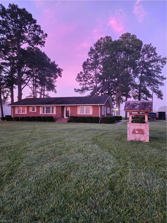 view of front of property featuring a carport and a yard