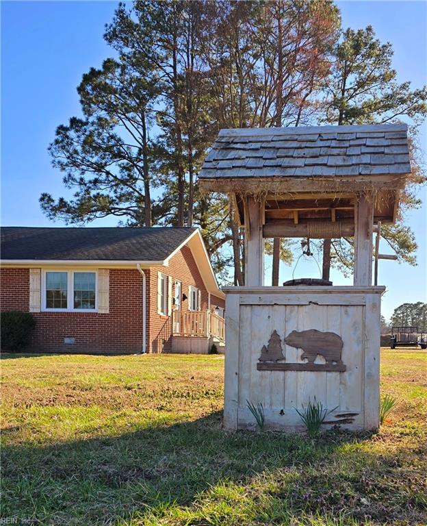 view of home's exterior with an outdoor structure, a lawn, brick siding, and crawl space