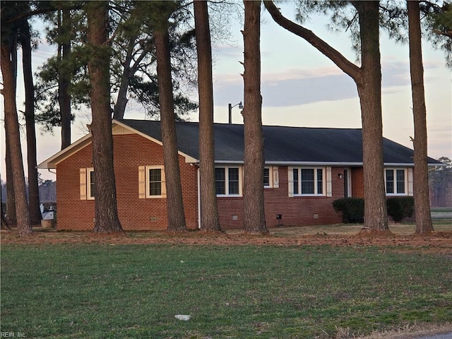 view of front of home featuring a front yard, brick siding, and crawl space