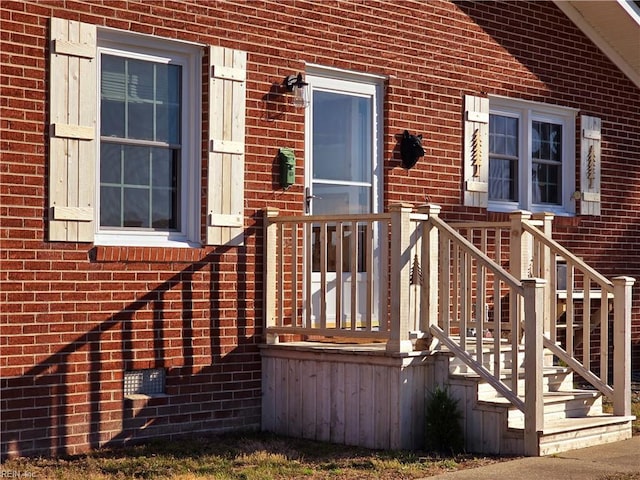 entrance to property featuring brick siding