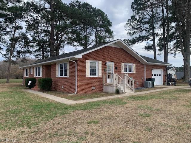 view of front of home featuring a front yard, central AC, a garage, crawl space, and brick siding