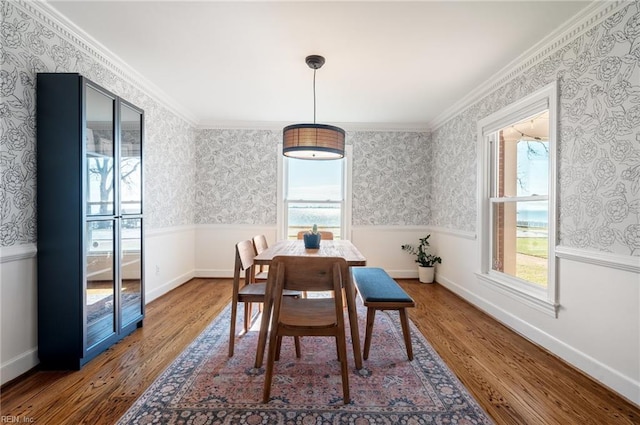 dining area with a healthy amount of sunlight, wallpapered walls, and wood finished floors