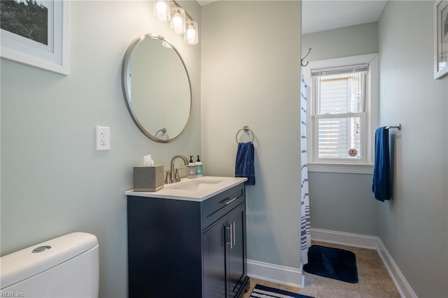 full bath with vanity, toilet, and baseboards