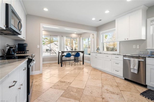 kitchen featuring baseboards, light stone counters, recessed lighting, appliances with stainless steel finishes, and white cabinets