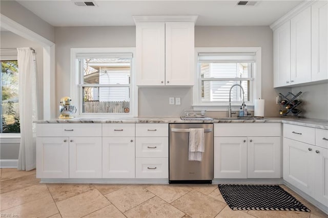 kitchen featuring stainless steel dishwasher, light stone counters, white cabinetry, and a sink