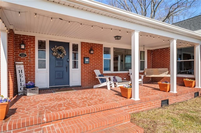 entrance to property featuring brick siding and a porch