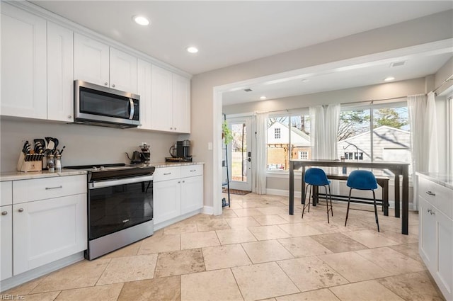 kitchen featuring white cabinetry, recessed lighting, baseboards, and appliances with stainless steel finishes