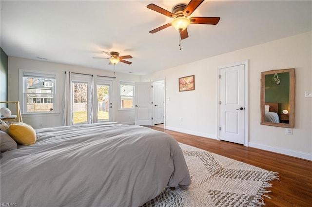 bedroom with access to exterior, a ceiling fan, baseboards, and wood finished floors