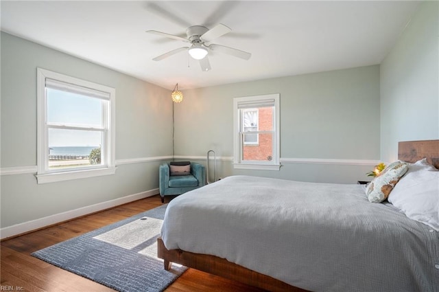 bedroom with ceiling fan, baseboards, and wood finished floors