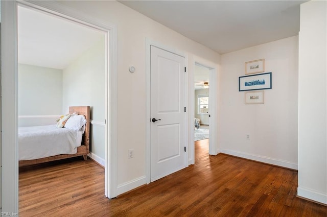 hall featuring baseboards and wood finished floors