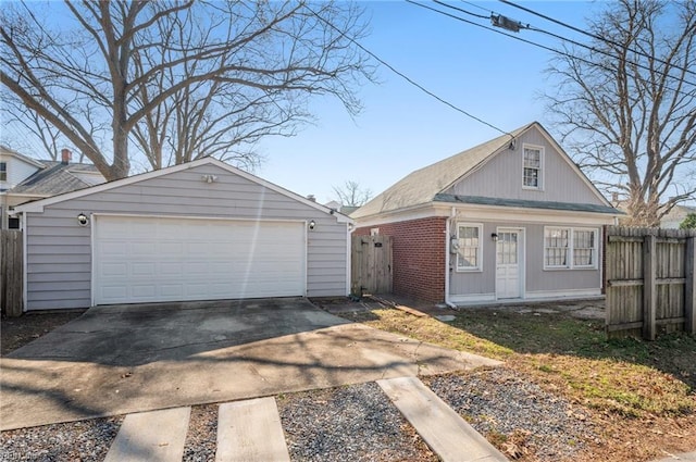 view of front of house featuring a garage, an outdoor structure, and fence