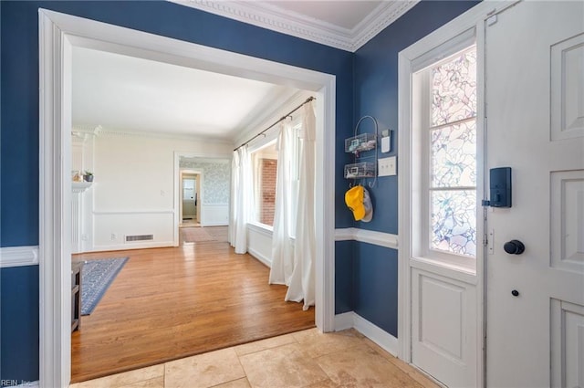 entryway featuring visible vents, wood finished floors, baseboards, and ornamental molding