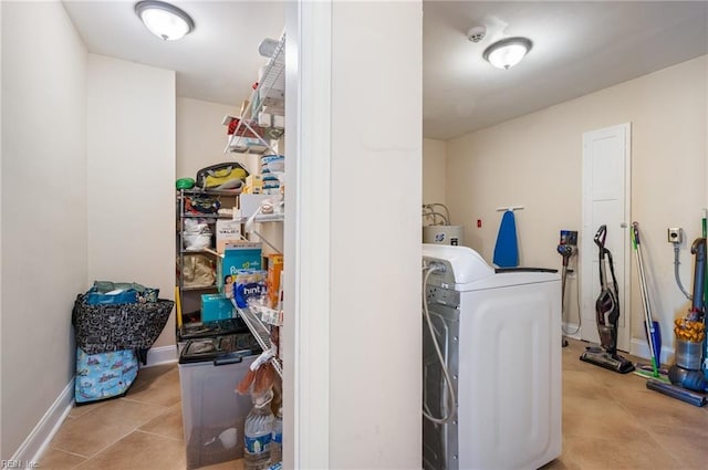 clothes washing area featuring baseboards, washer / clothes dryer, laundry area, and tile patterned flooring