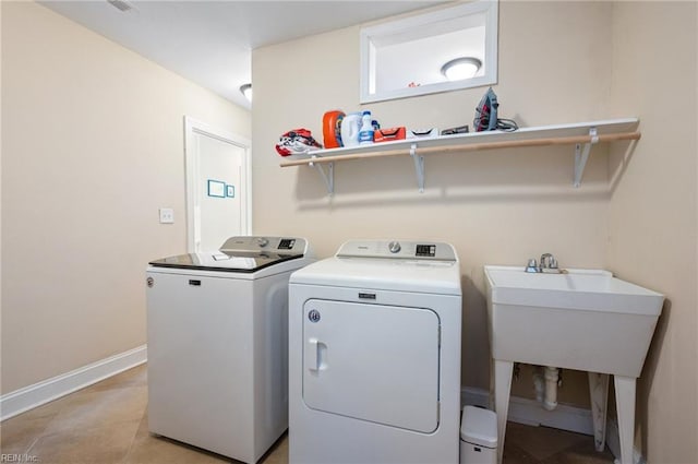 laundry room with washer and dryer, a sink, light tile patterned floors, baseboards, and laundry area