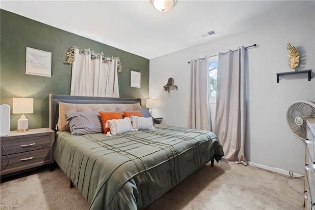 bedroom featuring baseboards, light carpet, and visible vents