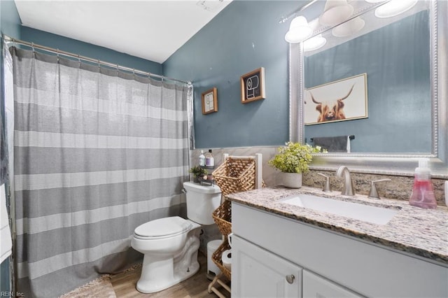 full bath with a shower with shower curtain, toilet, wood finished floors, and vanity