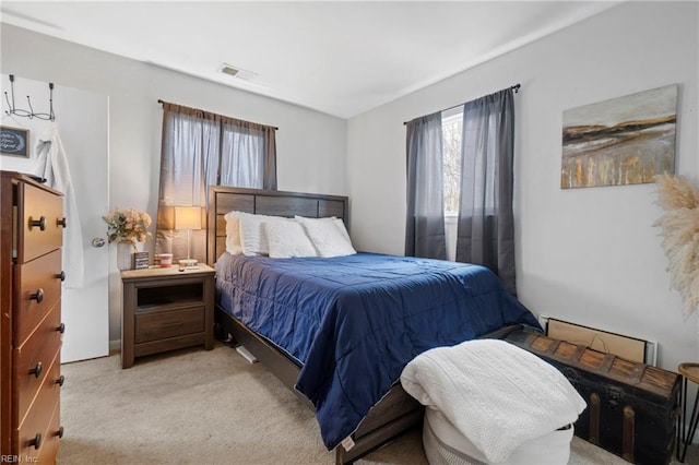 bedroom featuring visible vents and light colored carpet