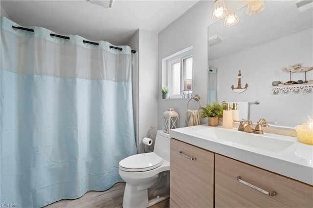 full bath with visible vents, toilet, a shower with curtain, wood finished floors, and vanity