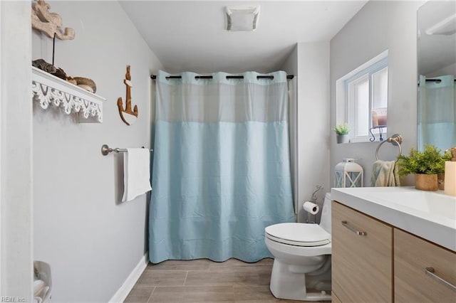 bathroom with curtained shower, toilet, vanity, and wood finished floors