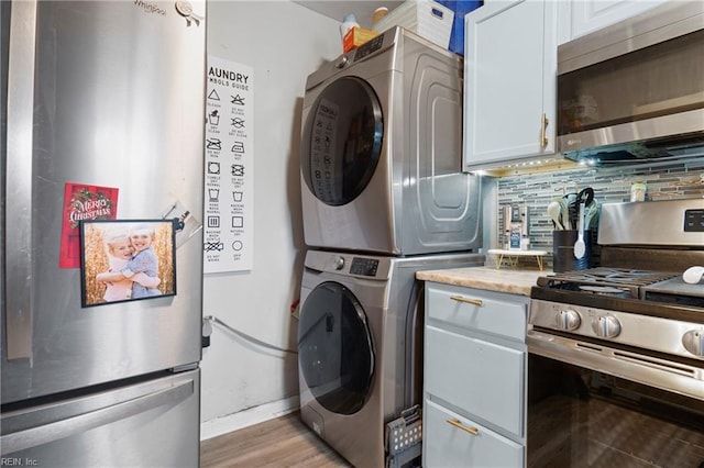 laundry area with laundry area, stacked washer and clothes dryer, and light wood finished floors