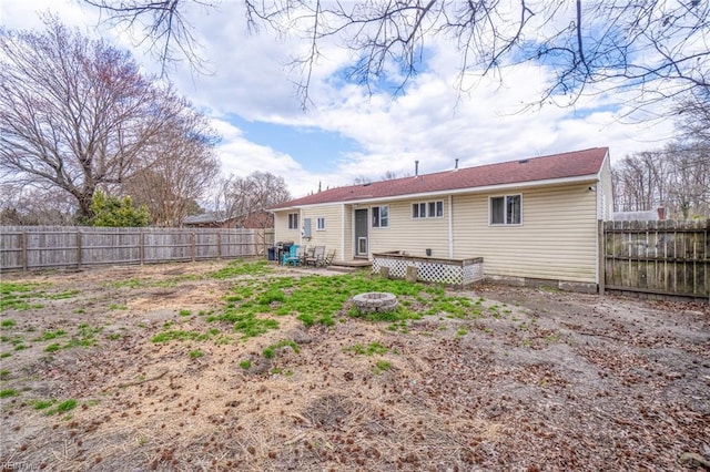 back of property featuring a fire pit, a fenced backyard, and entry steps