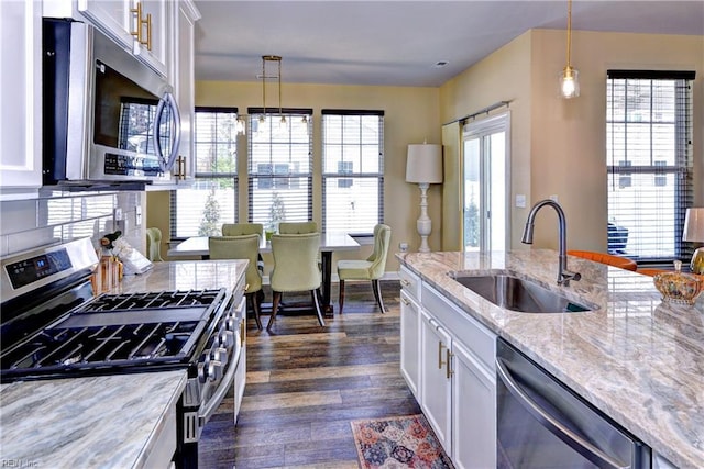 kitchen with dark wood-style floors, white cabinets, appliances with stainless steel finishes, and a sink