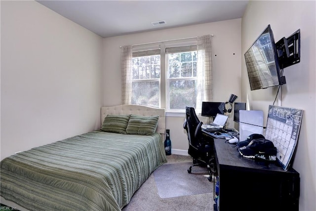 carpeted bedroom featuring baseboards and visible vents