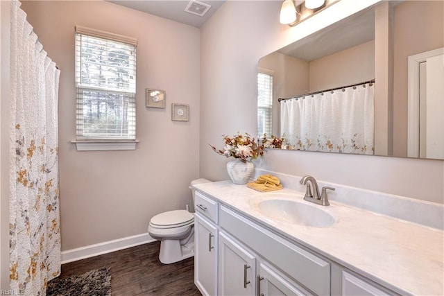 bathroom featuring visible vents, toilet, wood finished floors, baseboards, and vanity