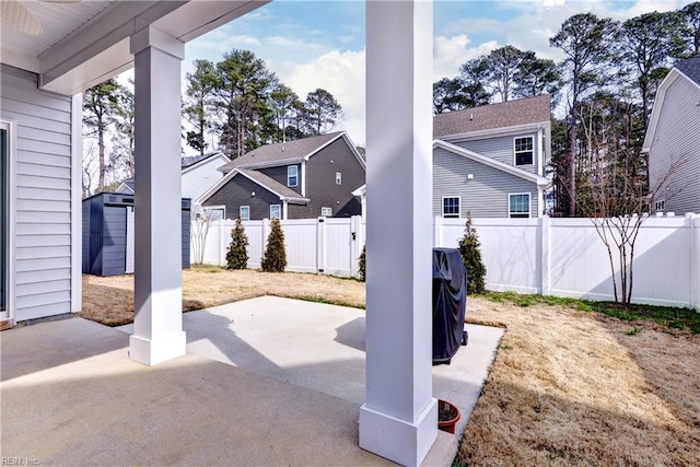 view of patio / terrace featuring an outbuilding, a shed, a residential view, and a fenced backyard