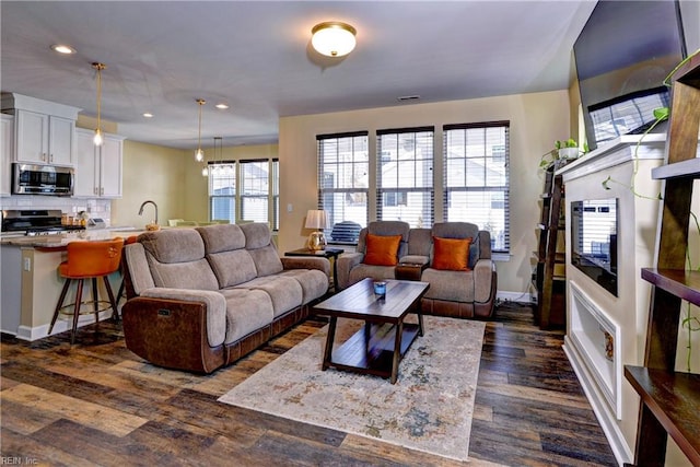 living room featuring recessed lighting, baseboards, and dark wood-type flooring