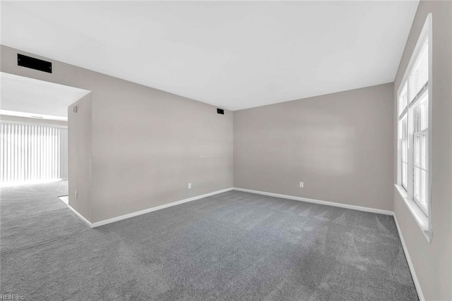 spare room featuring baseboards and carpet floors