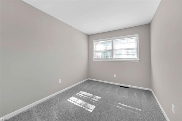 carpeted empty room featuring visible vents and baseboards