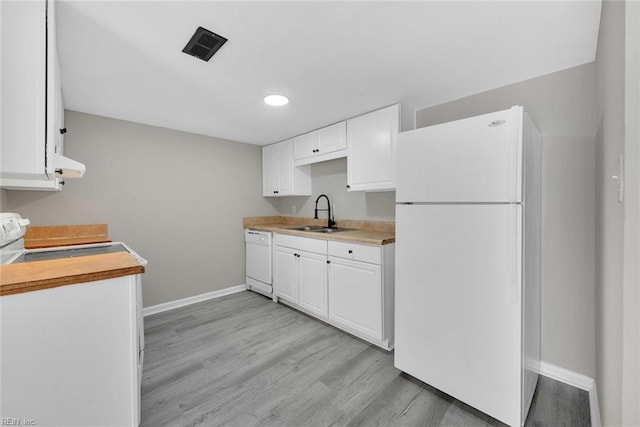 kitchen with white cabinetry, white appliances, light wood-type flooring, and a sink