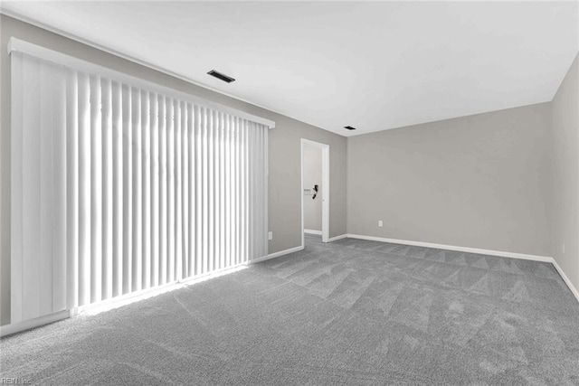 unfurnished room featuring carpet, visible vents, and baseboards