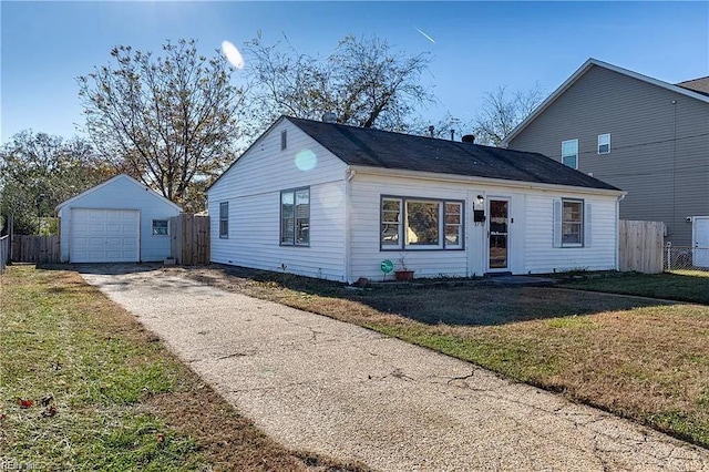 view of front facade featuring an outdoor structure, fence, a garage, and a front yard