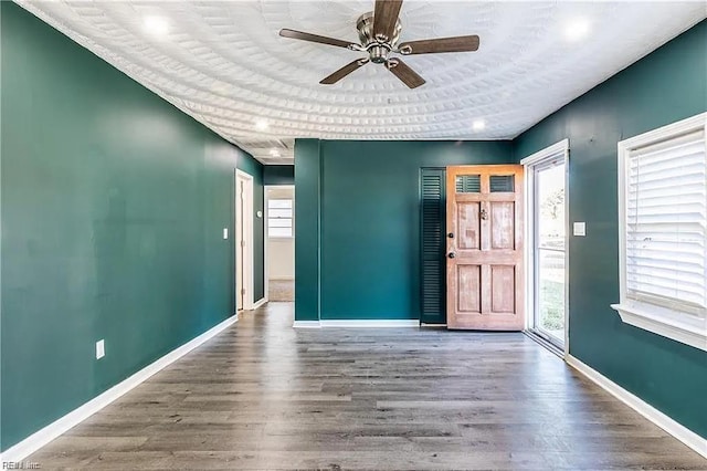 unfurnished room featuring ceiling fan, baseboards, and wood finished floors