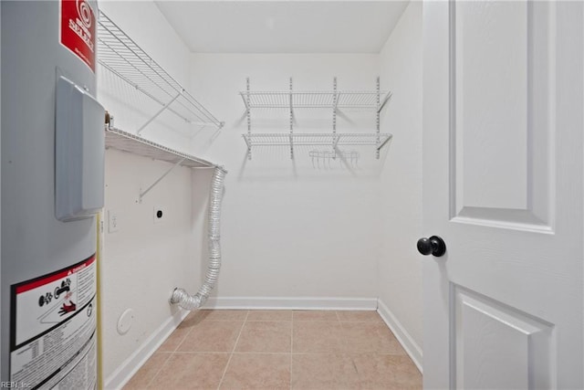 washroom featuring light tile patterned floors, baseboards, laundry area, electric dryer hookup, and electric water heater