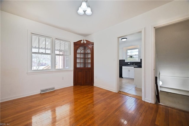 entryway featuring light wood-style flooring, baseboards, and visible vents