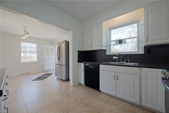 kitchen with freestanding refrigerator, a sink, black dishwasher, crown molding, and dark countertops